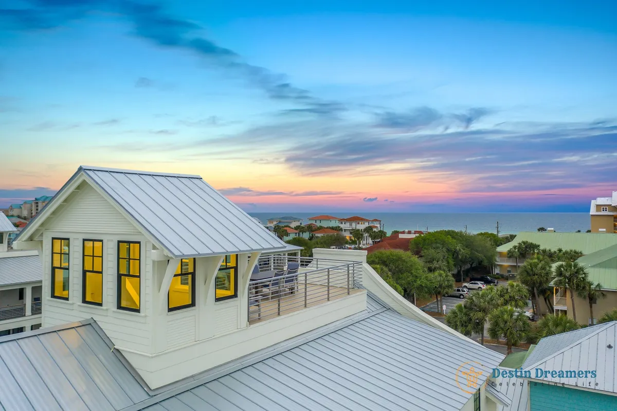 The photo spotlights the rooftop crow's nest seating area, offering a wide panoramic view over the Gulf and surrounding neighborhood. The clean architectural lines of the metal roof structure and the open sky reinforce the sense of luxury and exclusivity. This is a prime vantage point for sunbathing, sunset watching, and socializing outdoors.